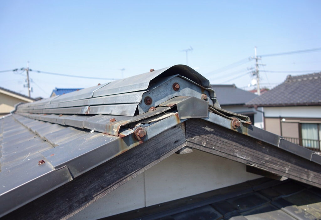 屋根の頂上部分にある棟板金が浮き上がり、継ぎ目に隙間ができている様子