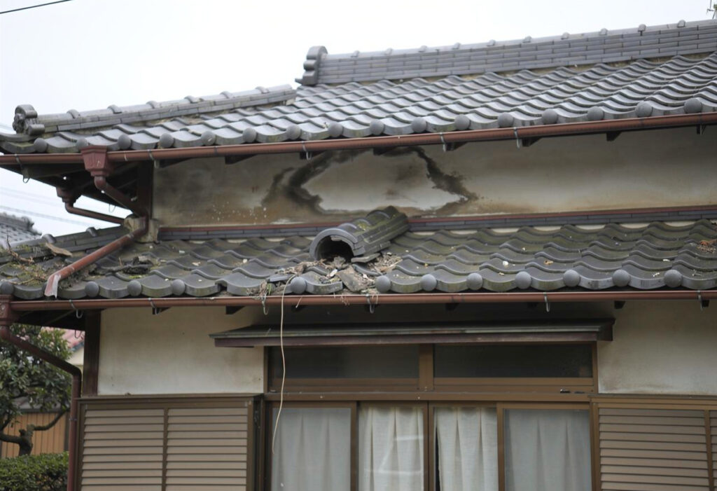 台風後の戸建住宅の屋根や外壁を地上から確認している様子