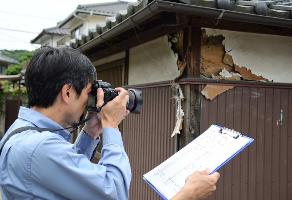 保険申請のために住宅の被害箇所を写真撮影し資料を作成している様子