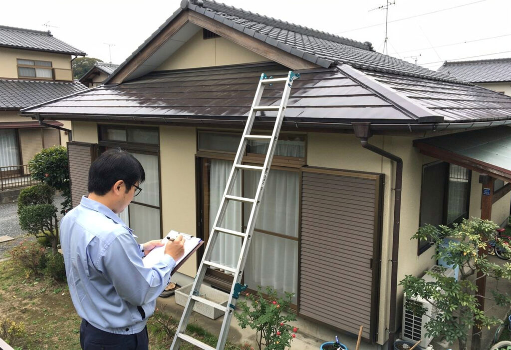 火災保険申請サポートの一環として、調査員が戸建住宅の屋根や外壁の被害状況を現地で確認している様子
